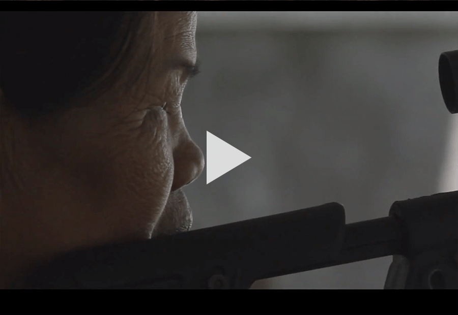 Asian Woman looking through a rifle